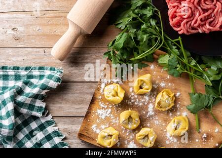 Uncooked pelmeni dumplings on rustic wooden table. typical russian food Stock Photo