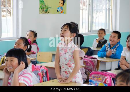 Students raising their hands to answer the teacher's question. Stock Photo