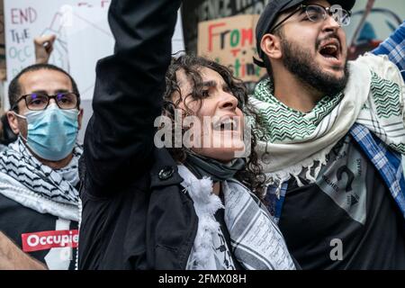 New York, United States. 14th May, 2021. A woman wearing keffiyeh attends  the rally. About 100 protesters staged rally against Israel during rally  Palestinian Liberation Within Our Lifetime Palistine on 53rd street.