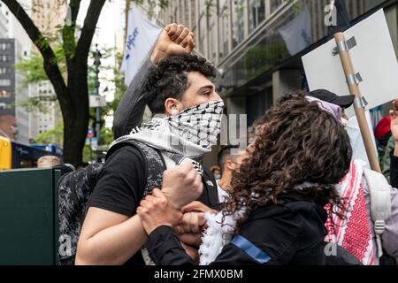 New York, United States. 14th May, 2021. A woman wearing keffiyeh attends  the rally. About 100 protesters staged rally against Israel during rally  Palestinian Liberation Within Our Lifetime Palistine on 53rd street.