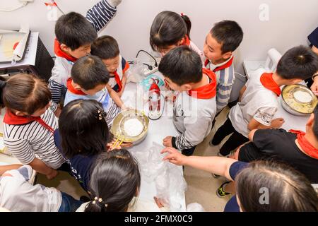 Students from Weiqiao Central Primary School Xiuning, Anhui, China learn to bake cookies for the first time. Stock Photo