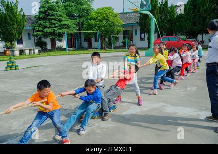 Students from Weiqiao Central Primary school of Xiuning, Anhui, China participate in a tug-of-war competition. Stock Photo