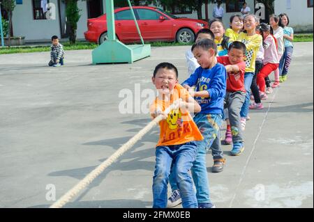 Students from Weiqiao Central Primary school of Xiuning, Anhui, China participate in a tug-of-war competition. Stock Photo