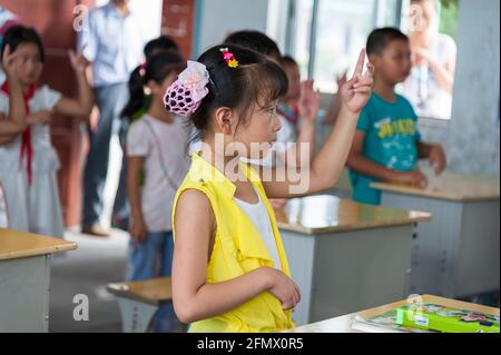 Students from Weiqiao Central Primary School in Xiuning, Anhui, China learning American Sign Language. Stock Photo