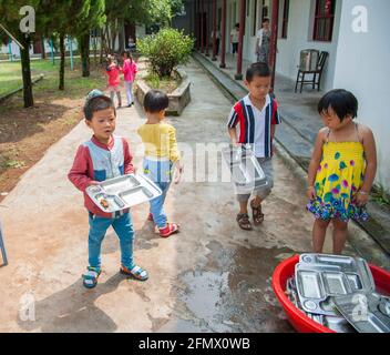 Student lining up for lunch and returning lunch plates in a rural school in Xiuning, Anhui, China Stock Photo