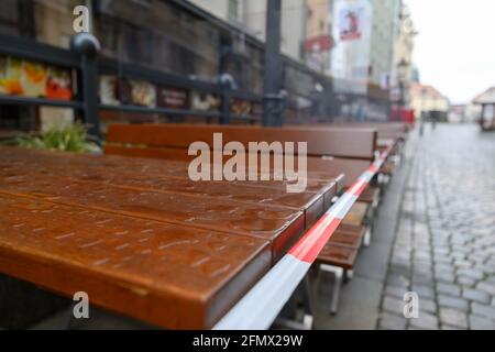 Dresden, Germany. 12th May, 2021. Rainwater stands on a table in the outdoor dining area of a restaurant in Münzgasse while being cordoned off with barrier tape. Credit: Robert Michael/dpa-Zentralbild/dpa/Alamy Live News Stock Photo