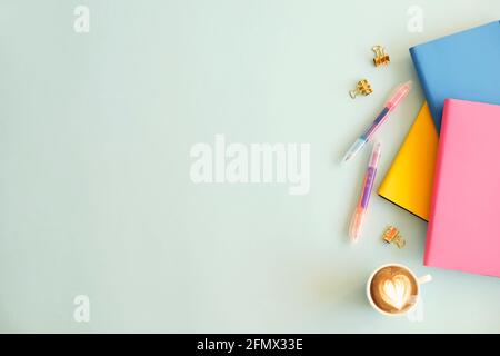 Feminine set of school supplies, yellow pink cover, blank sheet open notebook, pencil sharpener, colorful pen, binders, stickers & eraser, blue wooden Stock Photo