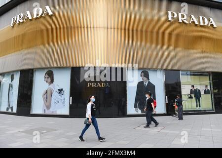 Beijing, China. 10th May, 2021. People wearing masks walk past Prada logo and store on Wangfujing Street in Beijing. (Photo by Sheldon†Cooper†/ SOPA Images/Sipa USA) Credit: Sipa USA/Alamy Live News Stock Photo