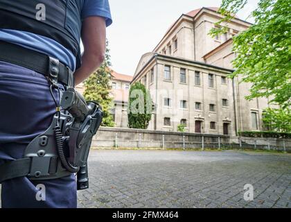 12 May 2021, Hessen, Frankfurt/Main: With his gun in his belt, an officer of the guard police stands in front of the synagogue in Frankfurt's West End at noon. During the night, Israeli flags had been set on fire in front of two synagogues in North Rhine-Westphalia. In Israel, the conflict between Israelis and Palestinians had come to a head since the beginning of the Muslim fasting month of Ramadan in mid-April. Photo: Frank Rumpenhorst/dpa Stock Photo