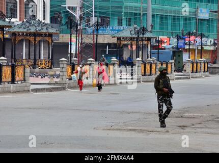 Srinagar, India. 12th May, 2021. A paramilitary trooper patrols through a closed market during a strict curfew imposed following the surge in COVID-19 cases in Srinagar.A day after several areas in Kashmir valley witnessed a huge rush of people ahead of Eid festival, strict curfew has been imposed in the valley as authorities enforced the lockdown to contain an alarming surge in coronavirus cases. Meanwhile, India recorded 348,421 new COVID-19 cases and 4,200 deaths in the last 24 hours. Credit: SOPA Images Limited/Alamy Live News Stock Photo