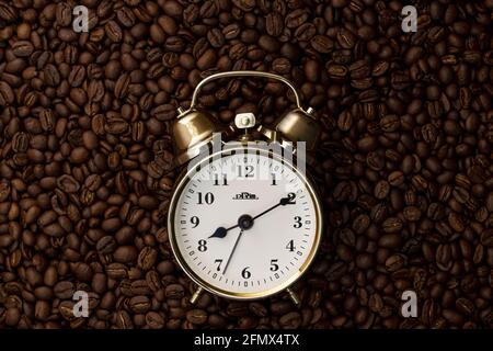 Old alarm clock with coffee beans background Stock Photo