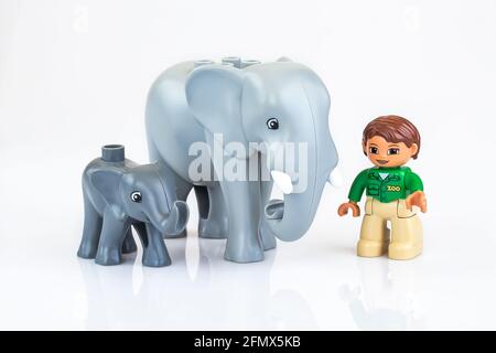 KHARKIV, UKRAINE - March 29th, 2020: Toy girl with toy elefant, plastic toys, pre-school education theme, isolated on white Stock Photo