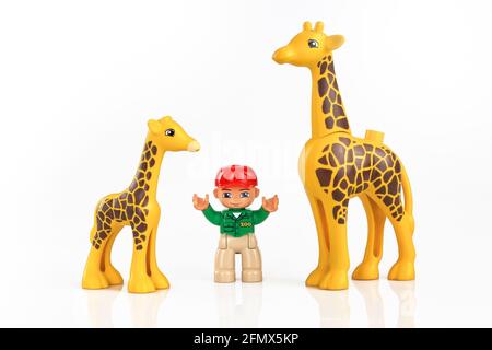 KHARKIV, UKRAINE - March 29th, 2020: Toy boy with toy giraffe, plastic toys, pre-school education theme, isolated on white Stock Photo
