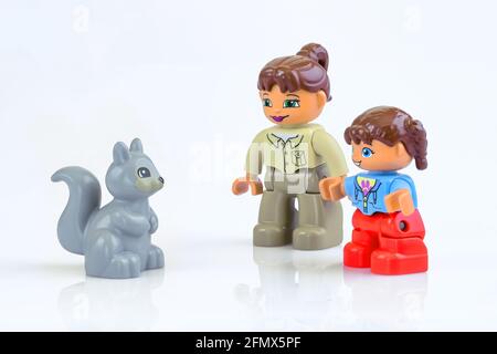 KHARKIV, UKRAINE - March 29th, 2020: Toy mother and daughter meet toy squirrel, plastic toys, pre-school education theme, isolated on white Stock Photo