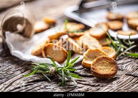 Crispy bake rolls baked on the metal rustic baking pan and served in the paper with rosemary tied by flax twine. Stock Photo