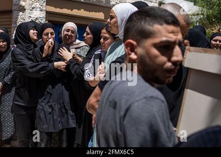 Lod, Israel. 12th May, 2021. Mourners attend the funeral of Kalil Awad, 52-years old, and his 16-years old daughter, Nadin Awad, who were killed early on Wednesday when a rocket fired from Gaza Strip hit their home in Dahmash village near the city of Lod. Credit: Ilia Yefimovich/dpa/Alamy Live News Stock Photo