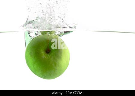 juicy green apple falls into the water on a white background, place under the text Stock Photo