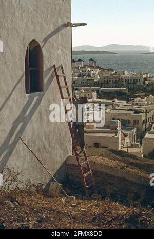 Scanned image   The old ways are the best ways on the Greek Island of Mykonos, a man uses long brushes and a ladder to traditionally paint his wall ci Stock Photo
