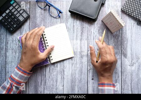 man's hand turning a pager of a diary and analyzing calendar date  Stock Photo