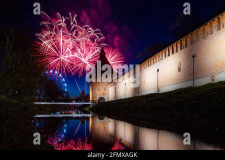 a fun city festival ends with a festive fireworks display. colorful explosions of fireworks in the evening sky are reflected in the water Stock Photo