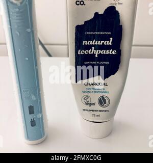 STOCKHOLM, SWEDEN - May 12, 2021: Charcoal toothpaste alongside an electric toothbrush Stock Photo