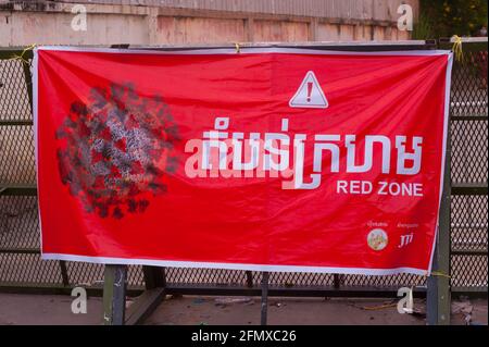 Phnom Penh, Cambodia. May 12th, 2021. after 4 weeks of the city being in total lockdown, the government has divided Phnom Penh into 3 color zones (red, orange & yellow) due to the ongoing COVID - 19 surge. a large colorful banner at the entrance to a 'Red Zone', meaning high risk of infection. many Cambodians are in quarantine on their own streets. credit: Kraig Lieb / Alamy Live News Stock Photo