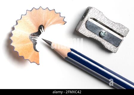 top view of pencil sharpener, pencil and shavings on white desk Stock Photo