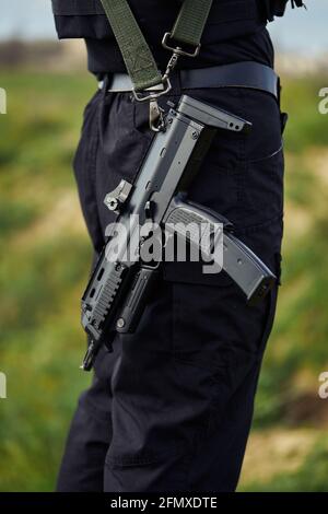 Close-up of a submachine gun of a police officer in black uniform Stock Photo