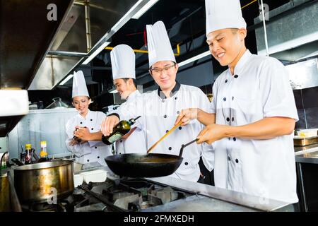 Asian Chefs in restaurant kitchen cooking Stock Photo