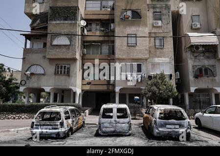 Lod, Israel. 12th May, 2021. Debris and torched vehicles litter the streets of the mixed Jewish Arab city of Lod following a night of Arab rioting against Jews throughout the country in a show of support for Hamas amid Israel’s Guardian of the Walls military operation in Gaza. The military conflict, now in it’s 3rd day, began following a salvo of rockets fired by Gaza’s Hamas terror group towards Jerusalem. Israeli government has declared a state of special emergency in Lod bestowing extended authority to the police. Credit: Nir Alon/Alamy Live News Stock Photo