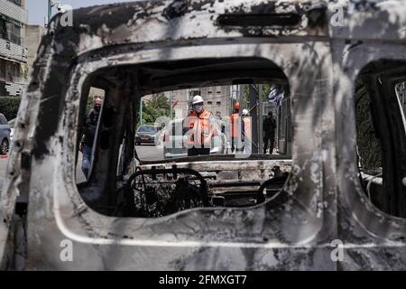 Lod, Israel. 12th May, 2021. Debris and torched vehicles litter the streets of the mixed Jewish Arab city of Lod following a night of Arab rioting against Jews throughout the country in a show of support for Hamas amid Israel’s Guardian of the Walls military operation in Gaza. The military conflict, now in it’s 3rd day, began following a salvo of rockets fired by Gaza’s Hamas terror group towards Jerusalem. Israeli government has declared a state of special emergency in Lod bestowing extended authority to the police. Credit: Nir Alon/Alamy Live News Stock Photo
