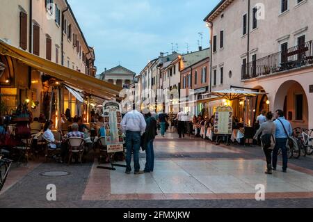 Tourists on Corso Umberto I  in the early evening at Bardolino, Lake Garda,Veneto Region,Italy. Many of the shops close at mid-night Stock Photo