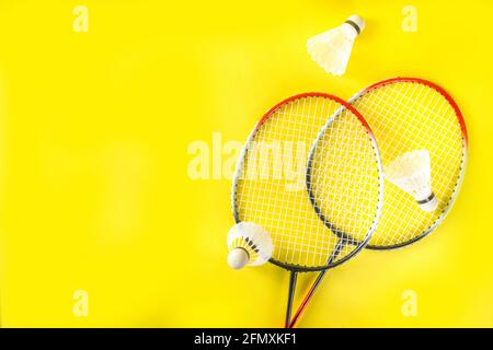 Summer sport activity concept. Two badminton paddle rackets with shuttlecocks on trend bright yellow background Stock Photo