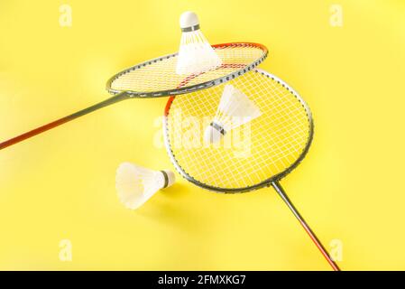 Summer sport activity concept. Two badminton paddle rackets with shuttlecocks on trend bright yellow background Stock Photo