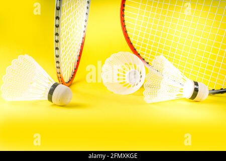 Summer sport activity concept. Two badminton paddle rackets with shuttlecocks on trend bright yellow background Stock Photo