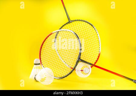 Summer sport activity concept. Two badminton paddle rackets with shuttlecocks on trend bright yellow background Stock Photo