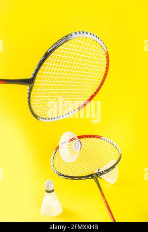 Summer sport activity concept. Two badminton paddle rackets with shuttlecocks on trend bright yellow background Stock Photo
