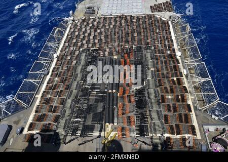 The U.S. Navy Ticonderoga-class guided-missile cruiser USS Monterey, displays thousands of illicit weapons on the rear deck, confiscated from smugglers in international waters May 6-7 in the North Arabian Sea. Stock Photo