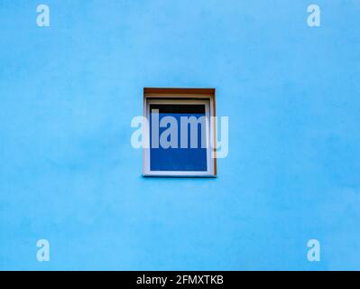 A modern window in the middle of a blue wall Stock Photo