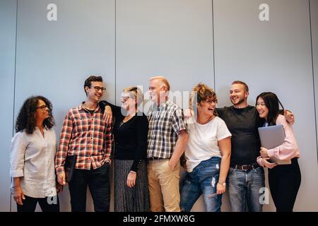 Portrait of creative business team standing together and laughing. Multiracial business people together. Stock Photo