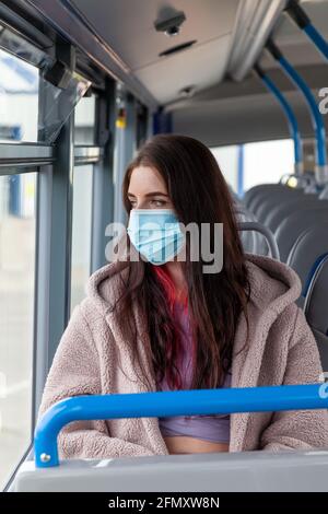 A young woman rides a bus and stares serenely out the window Stock Photo