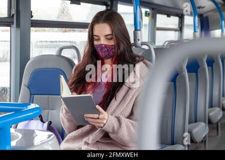 Young woman reading book in the bus Stock Photo