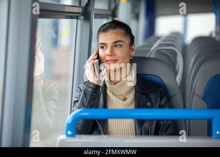 A woman holding her mobile phone to her ear on a bus Stock Photo