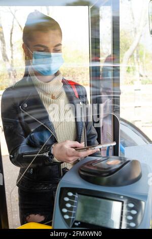 Woman using mobile payment on bus Stock Photo