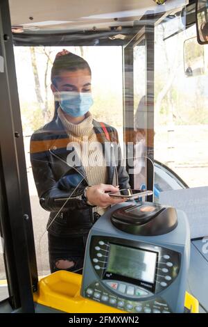 Woman using mobile payment on bus Stock Photo