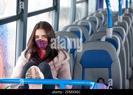 A young woman travelling in a bus with her feet up Stock Photo