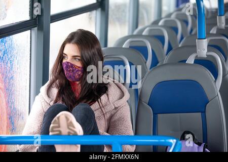 a woman sitting on a bus looking out the window Stock Photo