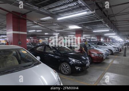 A multilevel car parking lot in the basement of a building with many cars parked Stock Photo