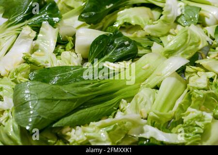 Bok choy and cabbage with oil and garlic on sheet pan ready to be roasted in the oven. Top view. Stock Photo