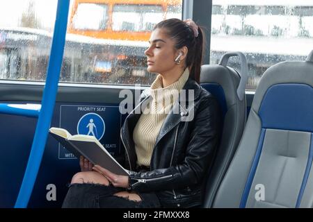 Woman sitting on a bus with her eyes closed Stock Photo